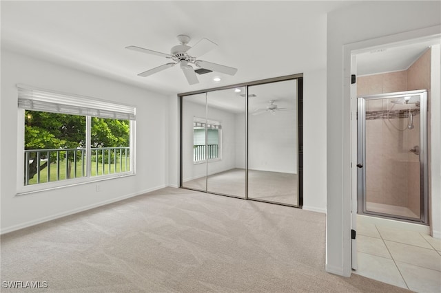 unfurnished bedroom featuring light tile patterned flooring, light colored carpet, baseboards, and ceiling fan