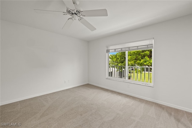 carpeted empty room with a ceiling fan and baseboards