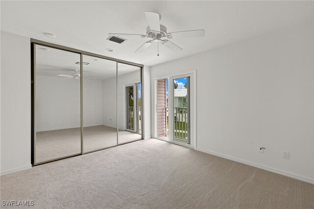 unfurnished bedroom featuring a closet, ceiling fan, multiple windows, and light carpet