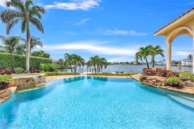 view of swimming pool featuring a water view and an in ground hot tub