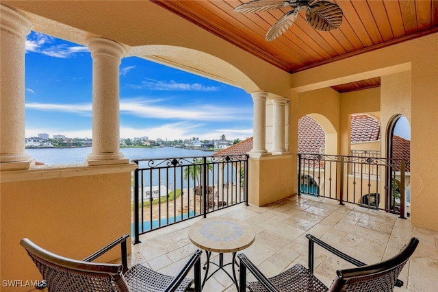 balcony featuring ceiling fan and a water view