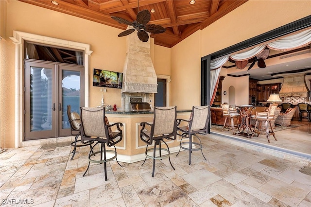 view of patio featuring ceiling fan, a fireplace, and a bar