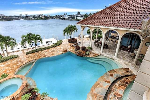 view of swimming pool with a water view, an in ground hot tub, and a patio area