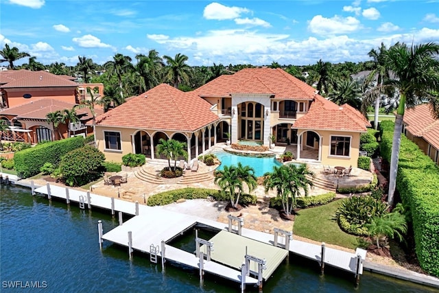 rear view of property featuring a water view and a patio area