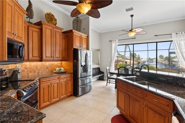 kitchen with ceiling fan, decorative backsplash, fridge, sink, and stove