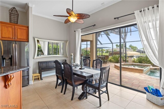 tiled dining area with ceiling fan and crown molding