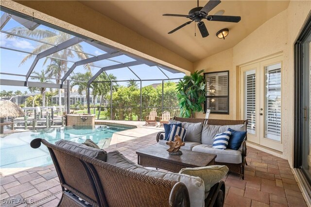 view of patio / terrace with ceiling fan, outdoor lounge area, a lanai, pool water feature, and a swimming pool with hot tub