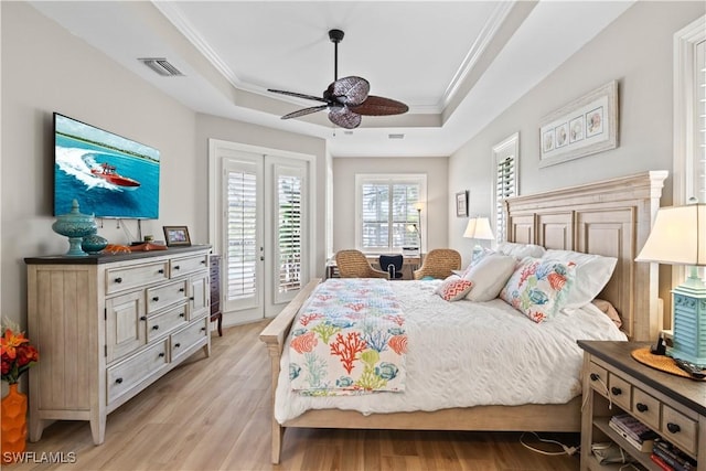 bedroom featuring light wood finished floors, visible vents, ornamental molding, access to exterior, and a tray ceiling