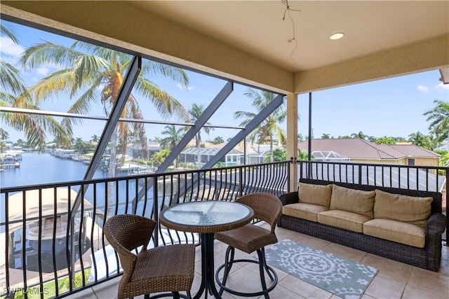 sunroom featuring a water view