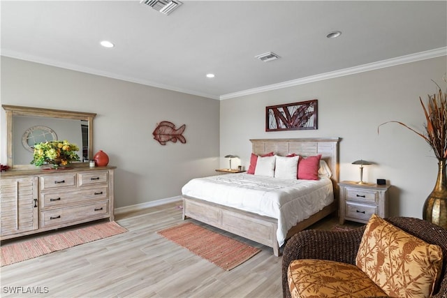 bedroom featuring visible vents, crown molding, and light wood finished floors