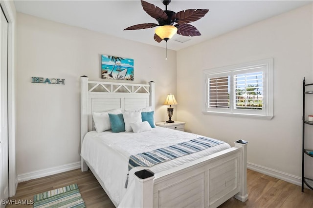 bedroom with ceiling fan, baseboards, and wood finished floors