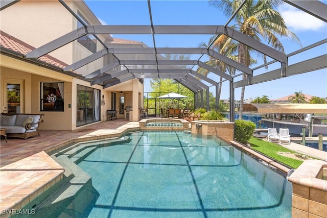 view of swimming pool featuring a patio area, glass enclosure, a pool with connected hot tub, and an outdoor hangout area