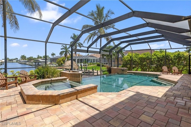 outdoor pool featuring a patio area, an in ground hot tub, a water view, and a lanai