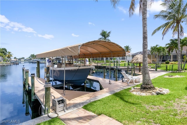 view of dock with a lawn and a water view