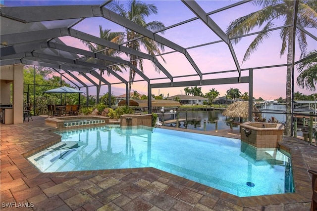 view of swimming pool with a water view, glass enclosure, boat lift, and a patio