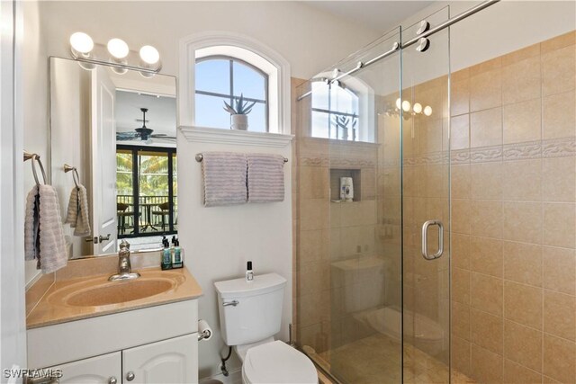 bathroom with ceiling fan, plenty of natural light, toilet, and vanity