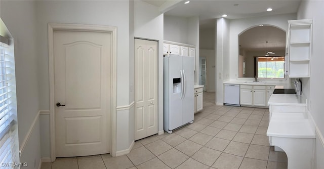 kitchen featuring light tile patterned flooring, white appliances, sink, and white cabinets