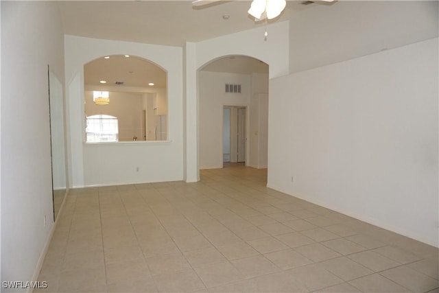 spare room with ceiling fan and light tile patterned floors