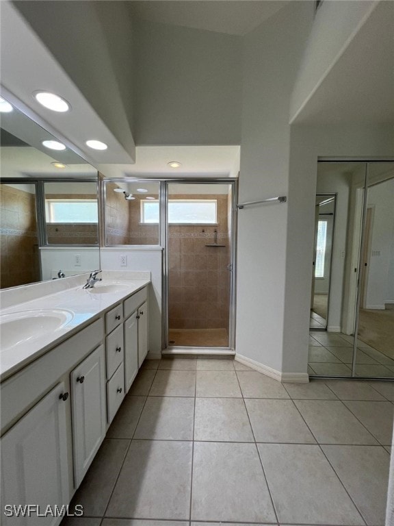 bathroom featuring tile patterned flooring, vanity, and walk in shower