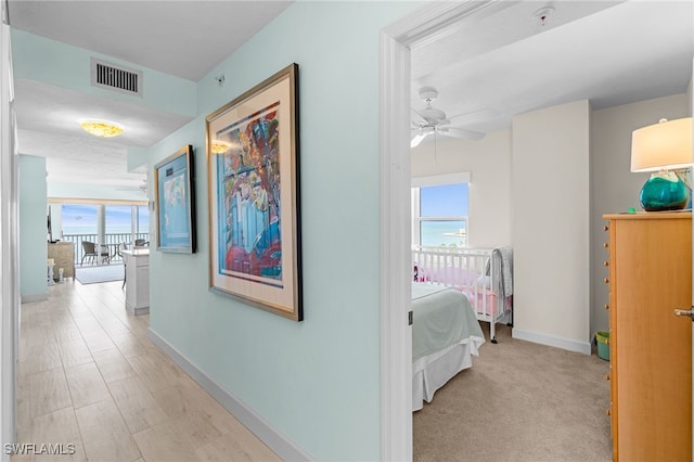 hallway with plenty of natural light and light colored carpet