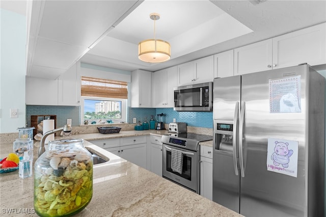 kitchen featuring white cabinets, tasteful backsplash, appliances with stainless steel finishes, and light stone counters