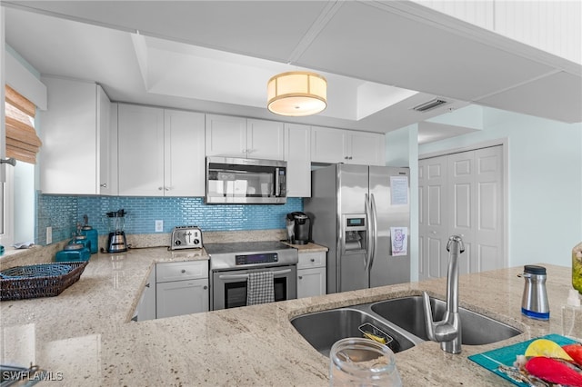 kitchen with backsplash, white cabinetry, light stone counters, sink, and stainless steel appliances