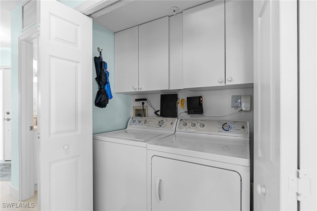 washroom with independent washer and dryer and cabinets