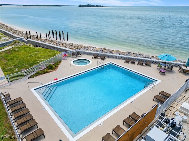 view of swimming pool featuring a community hot tub, a patio, and a water view