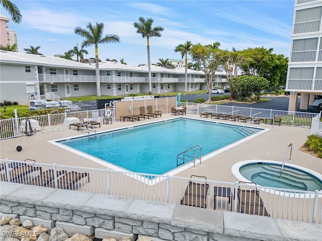 view of swimming pool with a community hot tub and a patio area