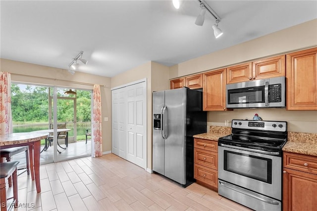 4965 Sandra Bay Dr Unit 103, Naples, FL 34109 - kitchen featuring appliances with stainless steel finishes, track lighting, and light stone counters