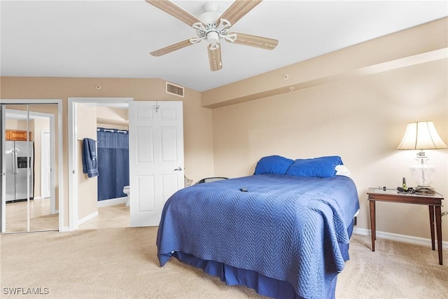 4965 Sandra Bay Dr Unit 103, Naples, FL 34109 - bedroom with stainless steel fridge with ice dispenser, light carpet, baseboards, ensuite bath, and a ceiling fan