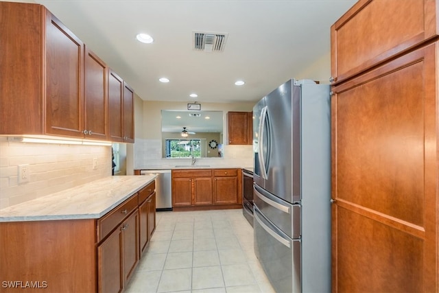 kitchen featuring stainless steel appliances, sink, ceiling fan, decorative backsplash, and light tile patterned flooring