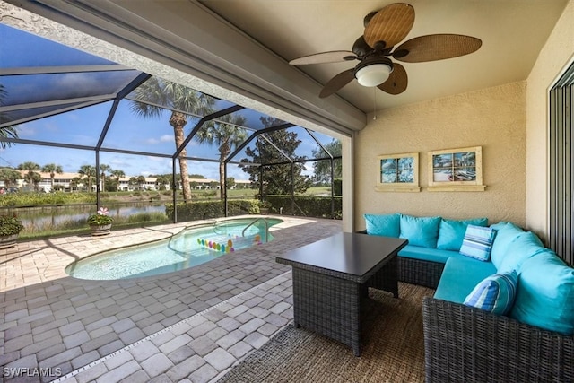 view of patio / terrace with a water view, a swimming pool with hot tub, ceiling fan, glass enclosure, and outdoor lounge area