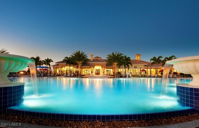 pool at dusk with a water slide and cooling unit