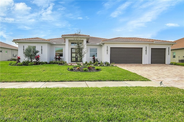 mediterranean / spanish home with a garage, central air condition unit, and a front yard