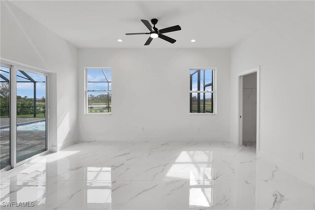 empty room featuring ceiling fan and a healthy amount of sunlight