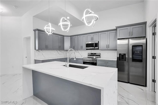 kitchen with sink, stainless steel appliances, light stone counters, a notable chandelier, and pendant lighting