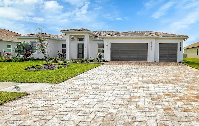 mediterranean / spanish-style house with a garage and a front lawn