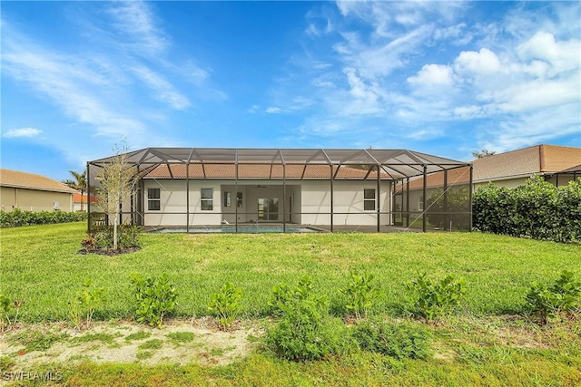 back of property featuring a lanai and a yard