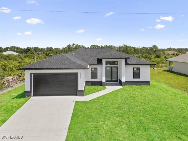 prairie-style home featuring a garage and a front lawn