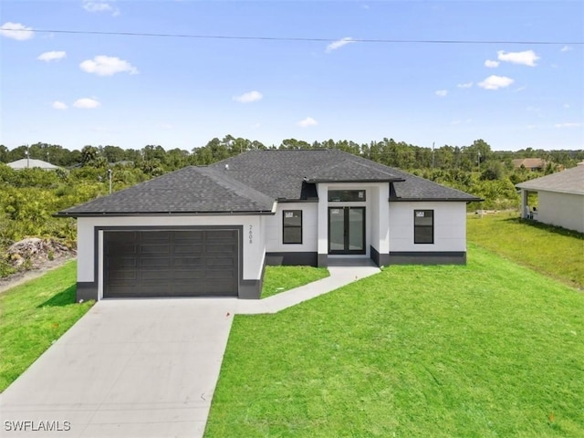 prairie-style house featuring a garage and a front lawn