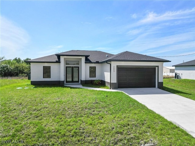 prairie-style house with an attached garage, driveway, roof with shingles, stucco siding, and a front yard