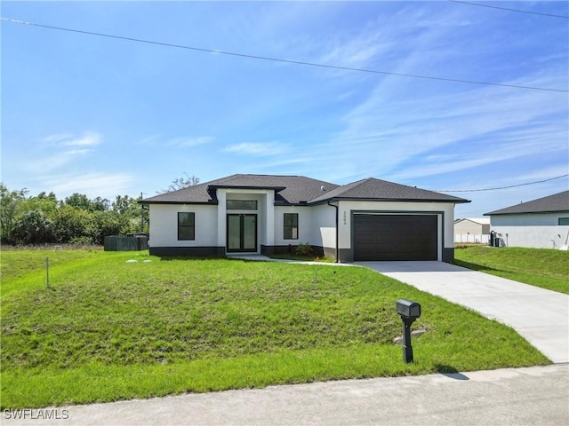 prairie-style home with driveway, an attached garage, a front lawn, and stucco siding