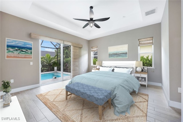 bedroom with ceiling fan, access to exterior, light wood-type flooring, and multiple windows