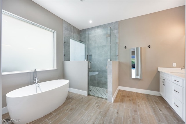 bathroom featuring vanity and independent shower and bath