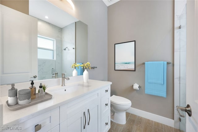 bathroom featuring a shower with door, vanity, wood-type flooring, and toilet