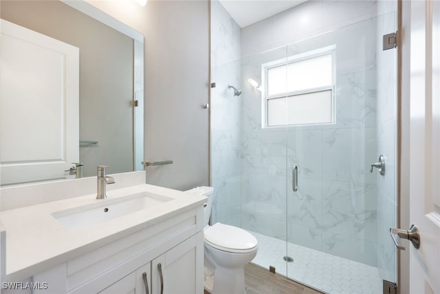 bathroom featuring hardwood / wood-style floors, vanity, toilet, and a shower with door