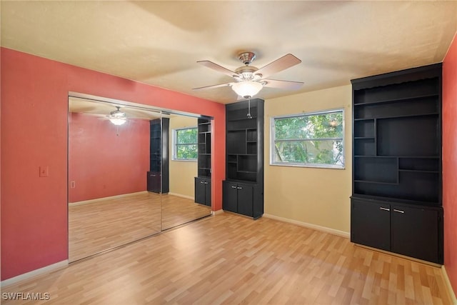 interior space featuring ceiling fan, light wood-style flooring, and baseboards