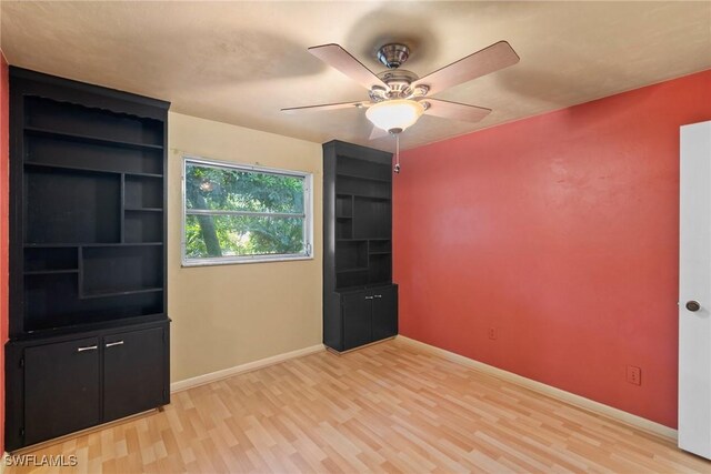 empty room with baseboards, a ceiling fan, and light wood-style floors