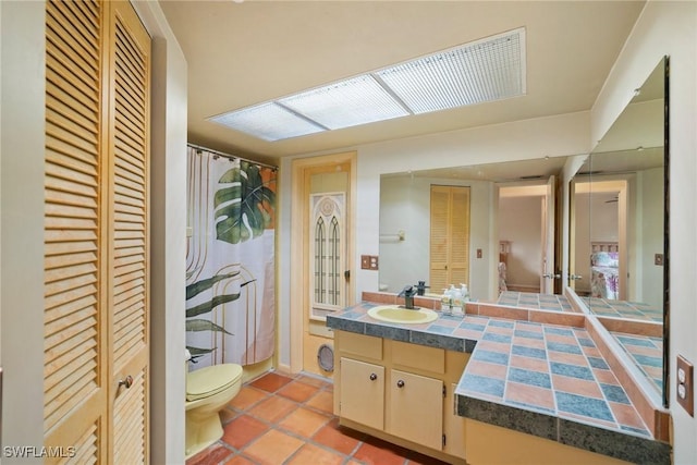 bathroom with a shower with shower curtain, toilet, tile patterned flooring, vanity, and a closet